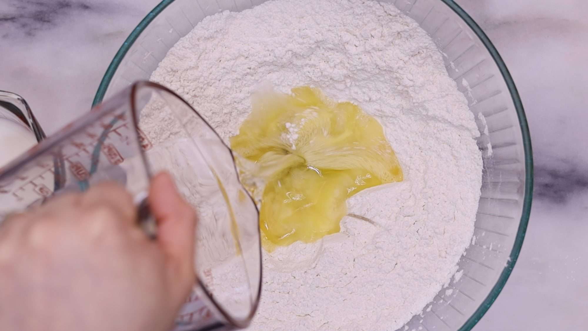 Add the milk and water while stirring continuously with a wooden spoon. Continue this process until you achieve a dough that is wet, stretchy, and sticky.