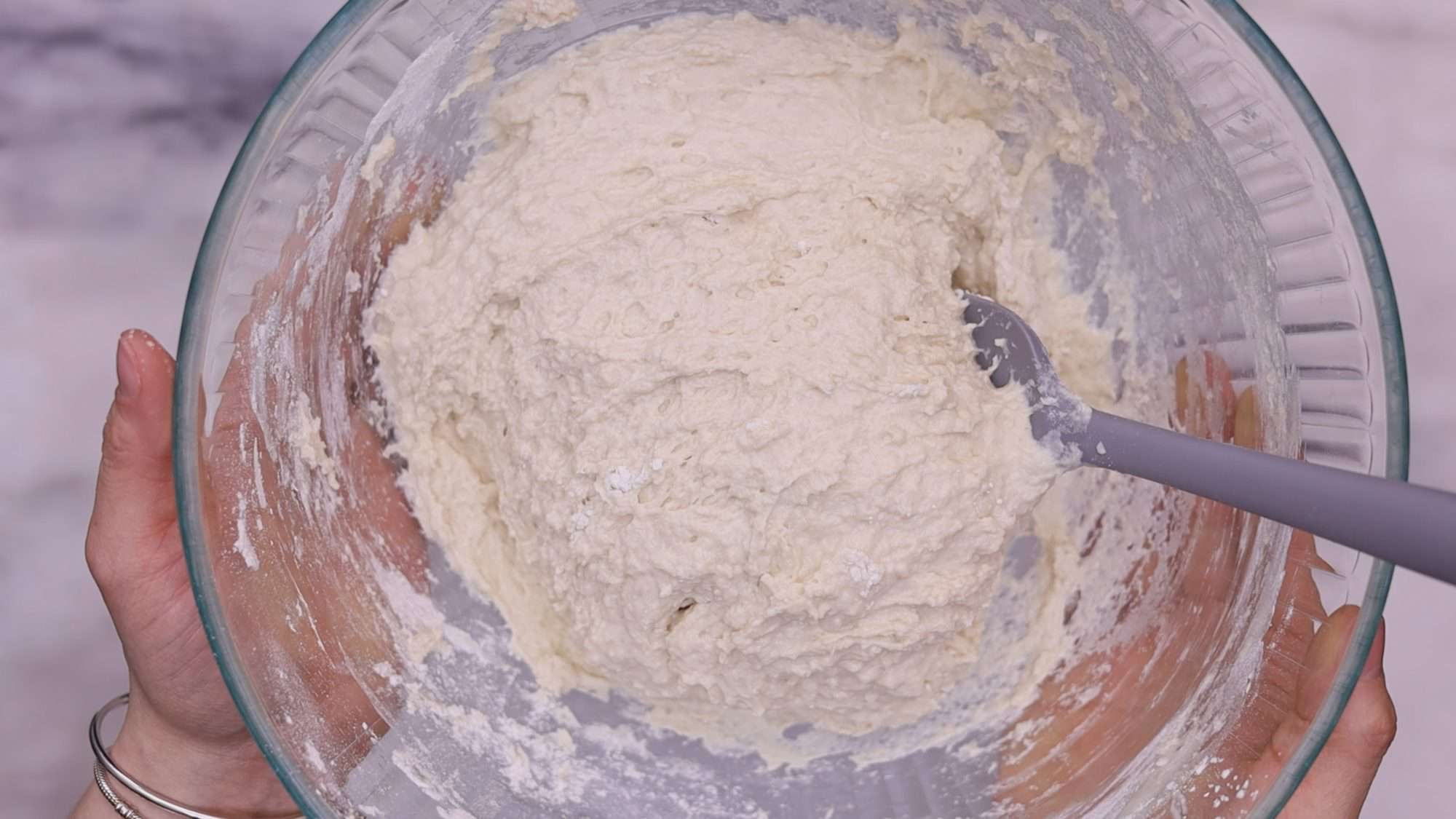 Add the milk and water while stirring continuously with a wooden spoon. Continue this process until you achieve a dough that is wet, stretchy, and sticky.