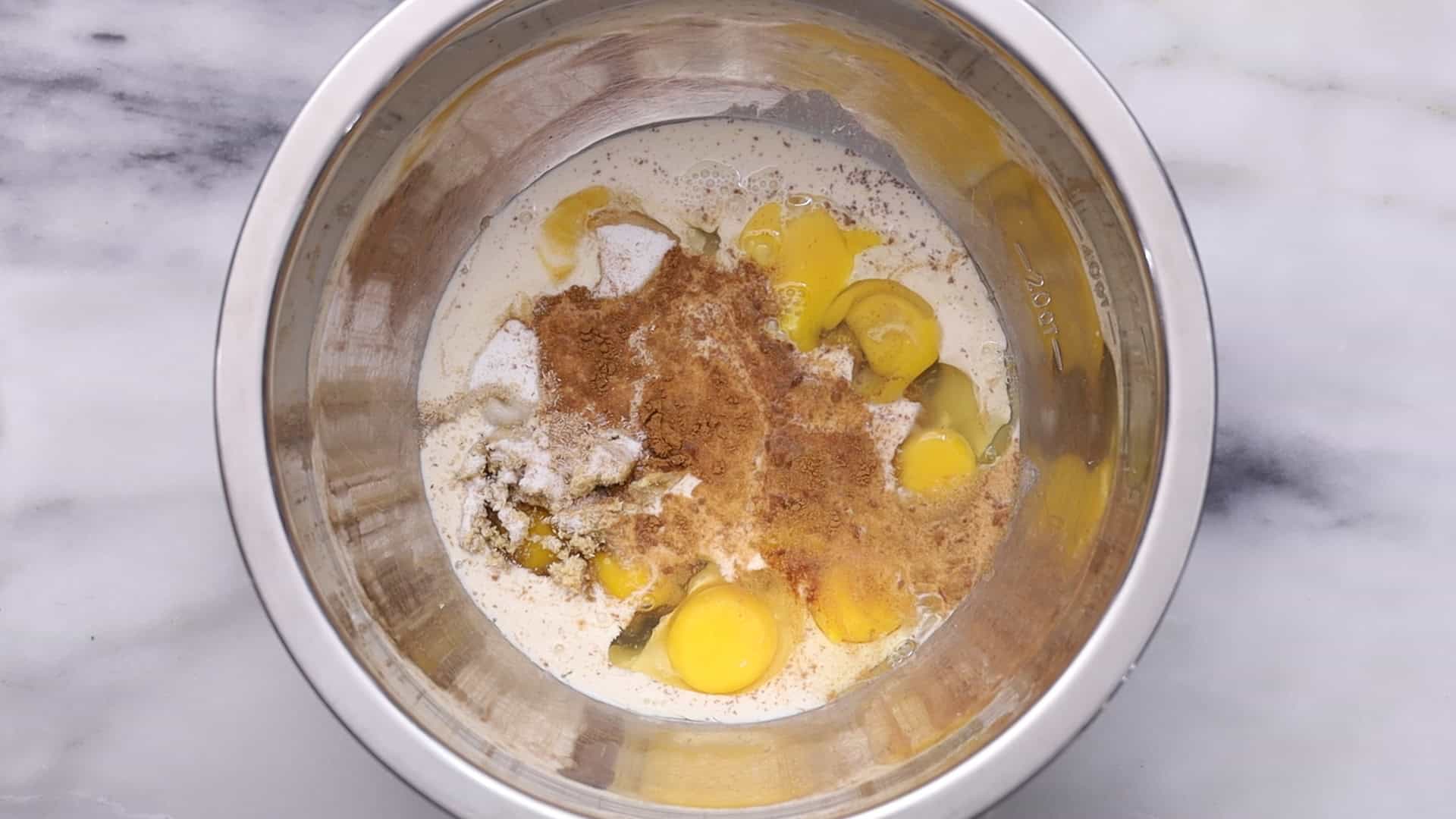 Mix cream, milk, sugars, vanilla, bourbon, spices, melted butter, eggs, and yolks.
