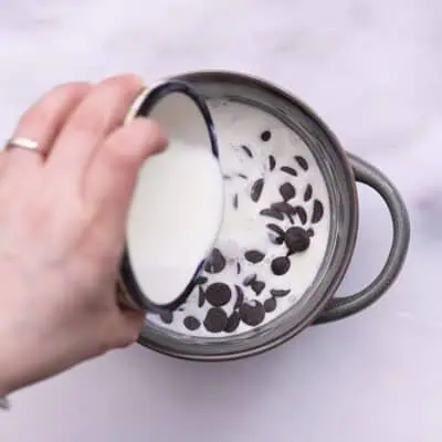 Pouring Hot milk and chocolate chips in a bowl