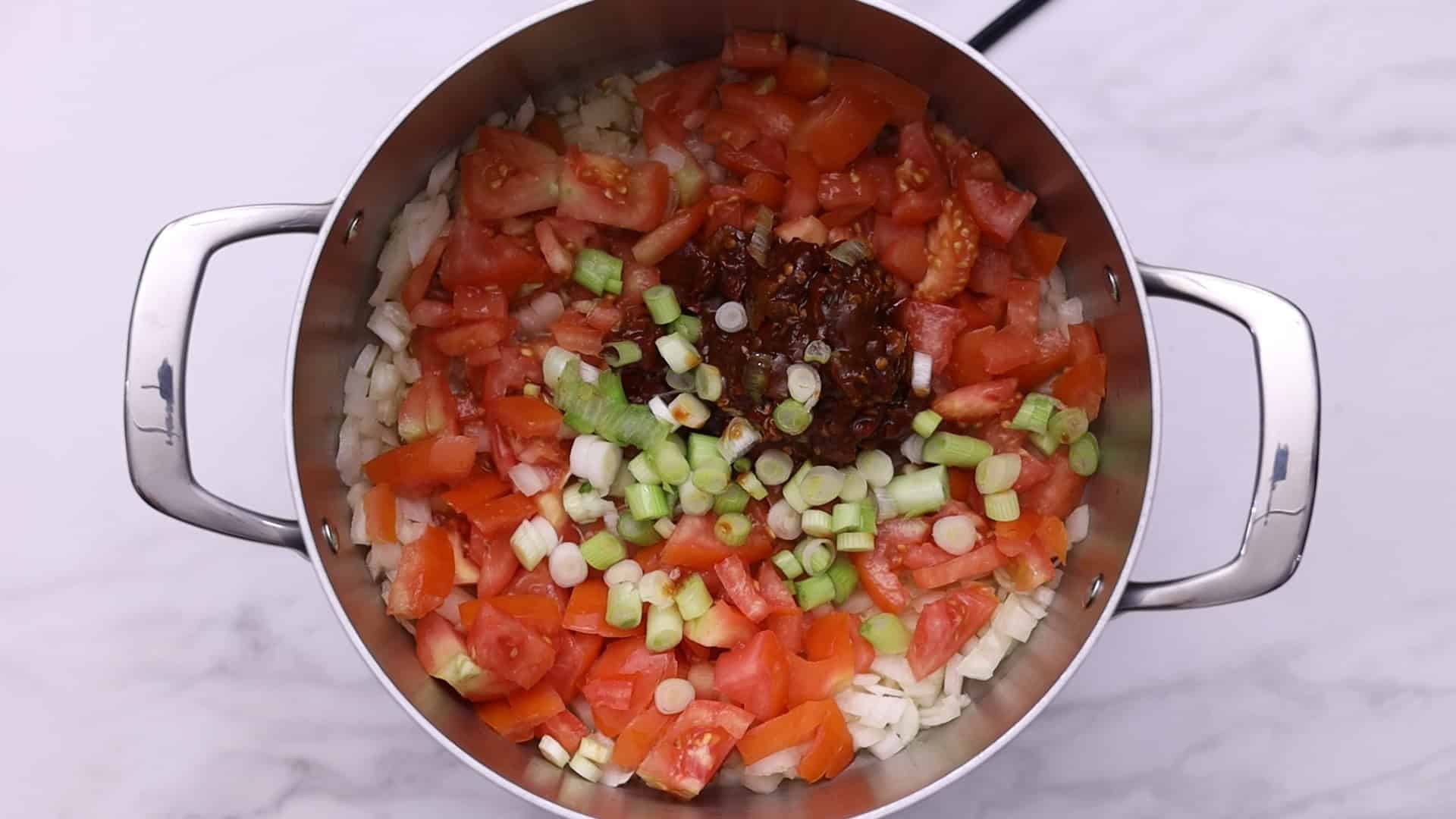 Sauté tomatoes, onion, chipotle pepper, the white part of the scallion until soft