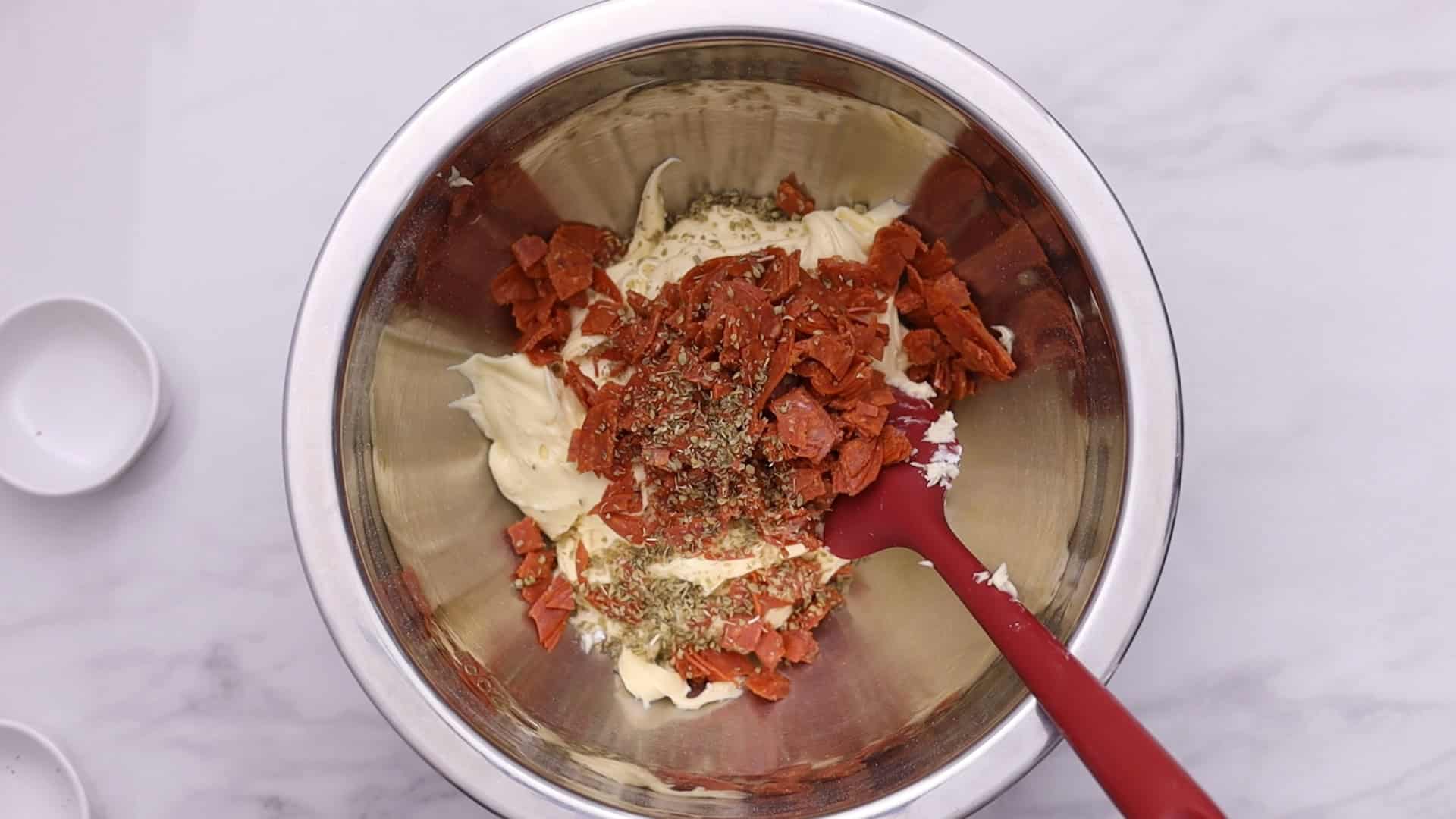Añada la pimienta, el orégano y el pepperoni.