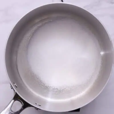 Heat sugar in a saucepan over medium heat, stirring