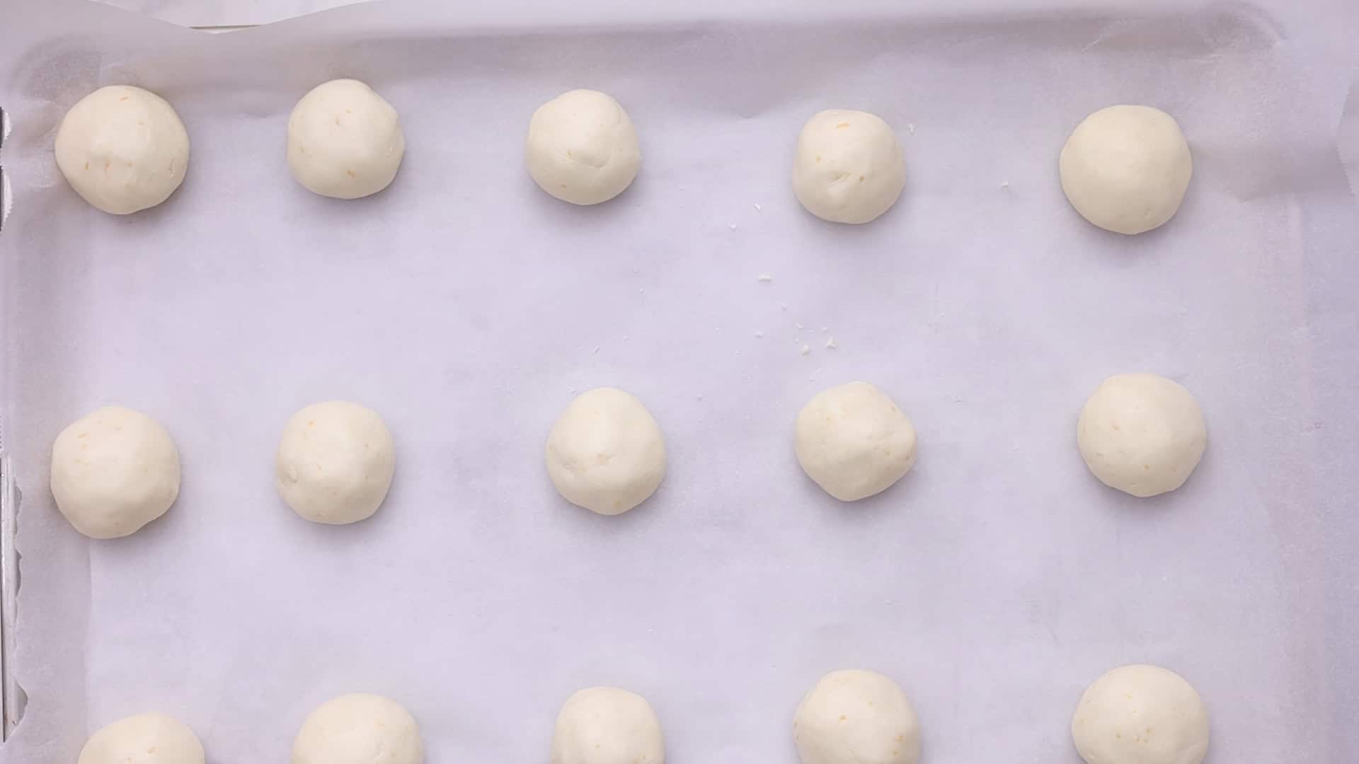 Knead, form 50 g balls, and place on the baking sheet. Bake 15-20 minutes until lightly golden brown.