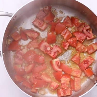 Add tomatoes, turmeric, black pepper, and chicken bouillon.