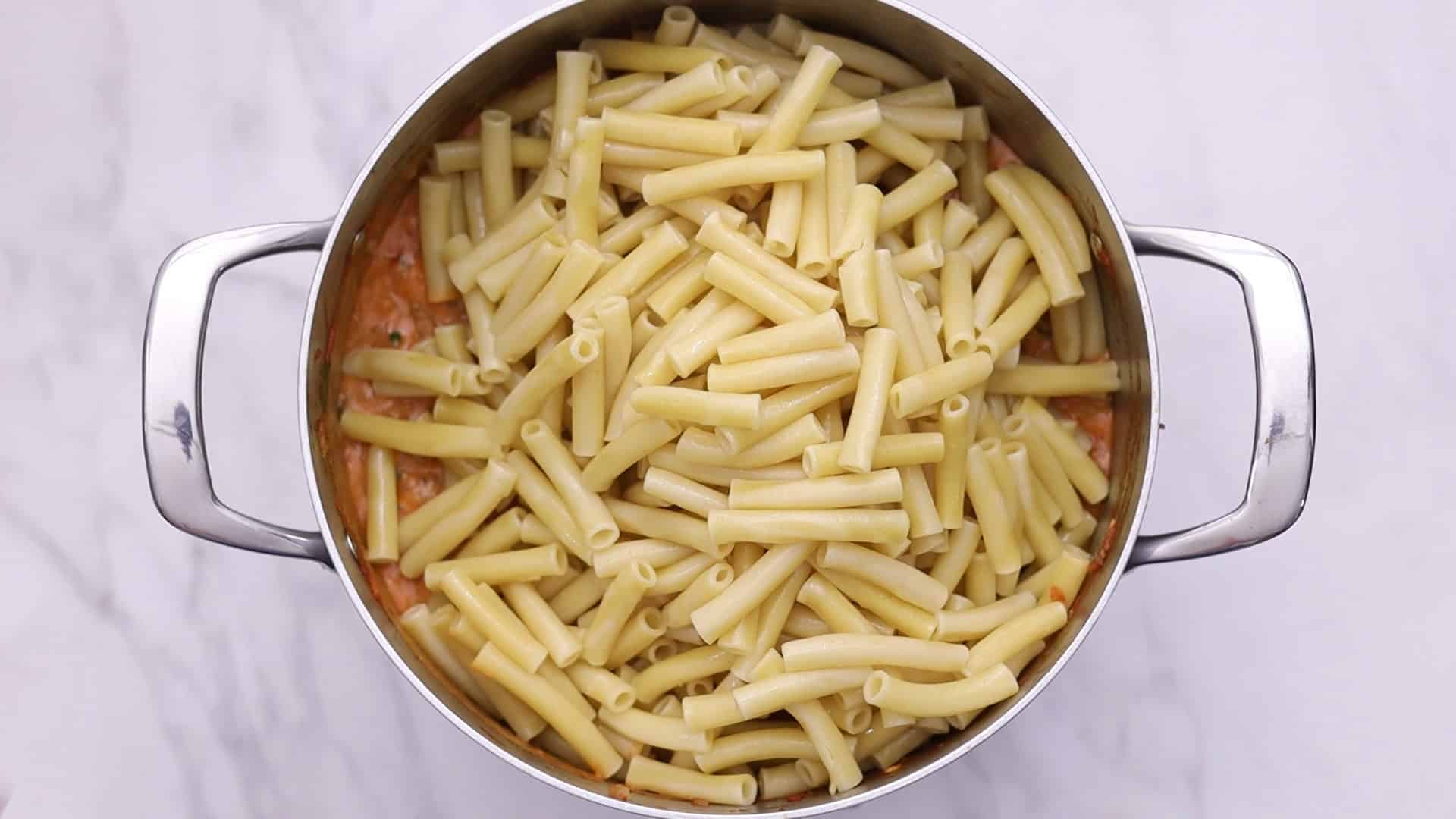 Mezcle la salsa con la pasta y pase la mitad a la fuente de horno.