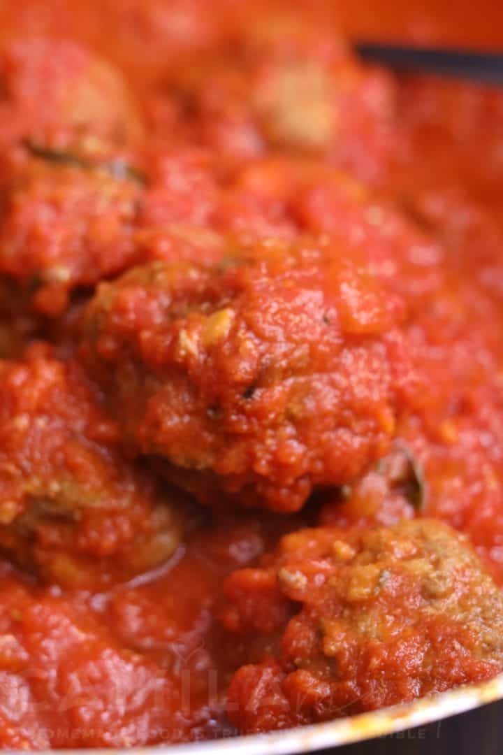Albóndigas crudas en una bandeja de hornoen una olla
