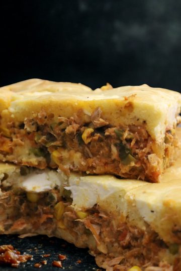 A slice of tuna with cheese and vegetables.