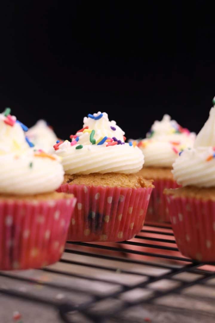 Cupcakes de Cumpleaños 10 Un primer plano de magdalenas sobre una rejilla de enfriamiento.