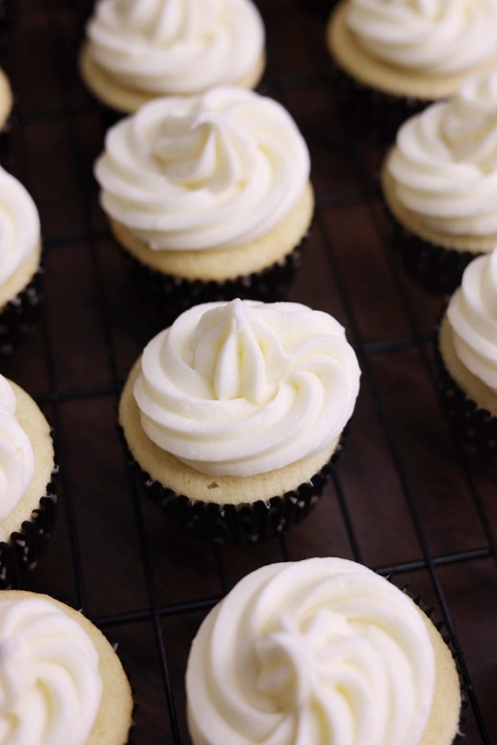 A cooling rack with cupcakes on it.