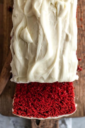 Red Velvet Loaf Cake with cream cheese frostingin a wooden board